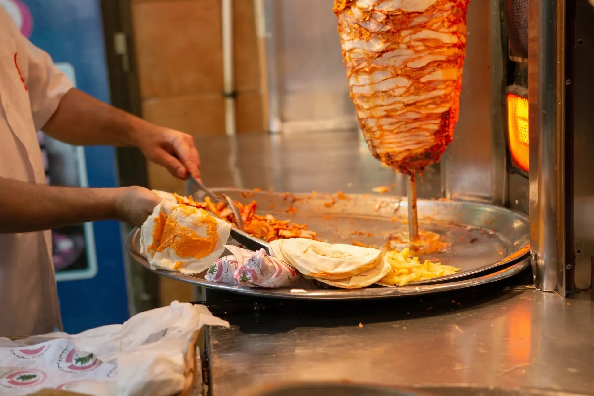 A close-up of a shawarma, a popular Middle Eastern street food, with layers of grilled meat, fresh vegetables, and flavourful sauces.