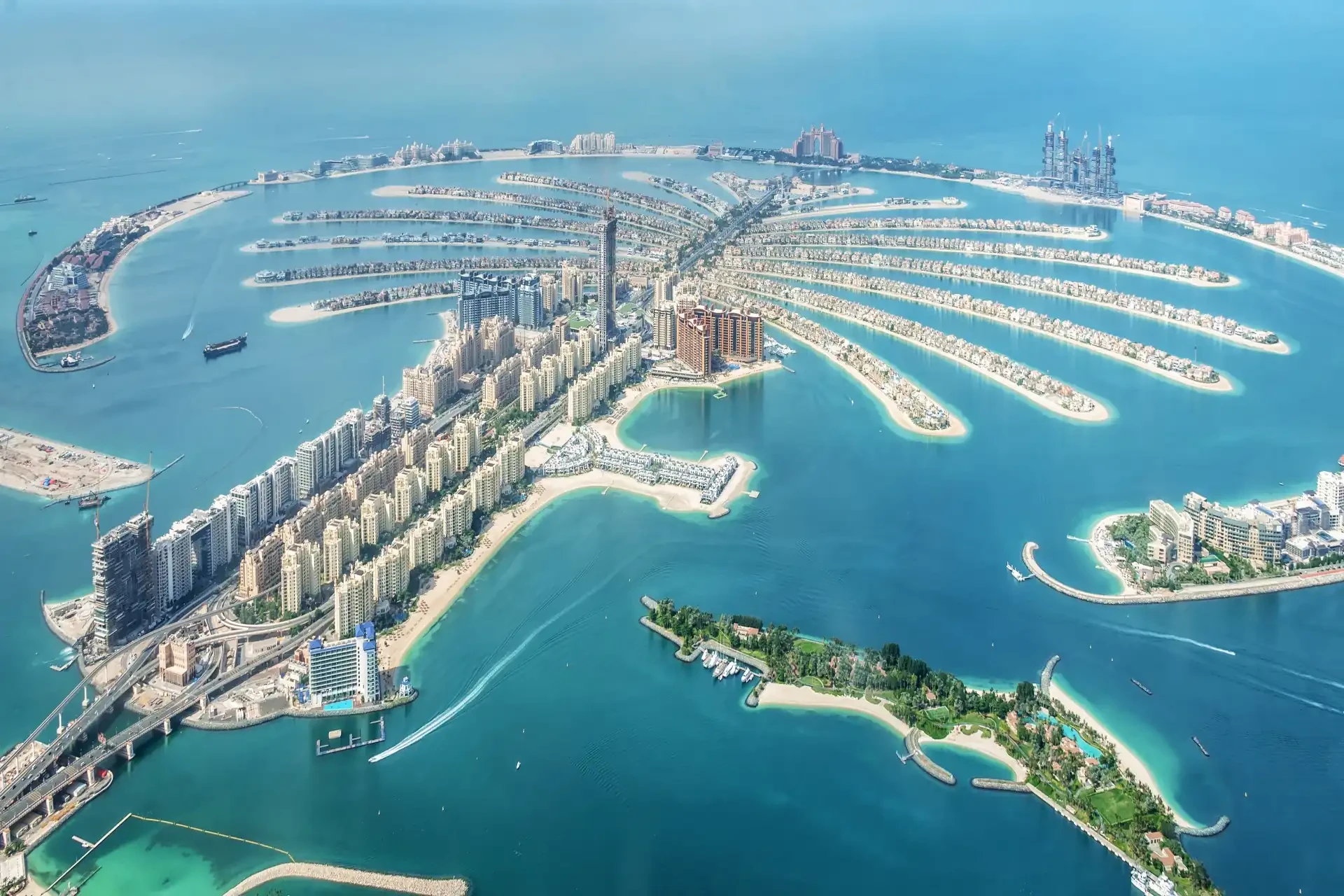 The Palm Jumeirah An aerial view of The Palm Jumeirah, an iconic man-made palm-shaped archipelago, surrounded by azure waters, luxury resorts, and residential structures.