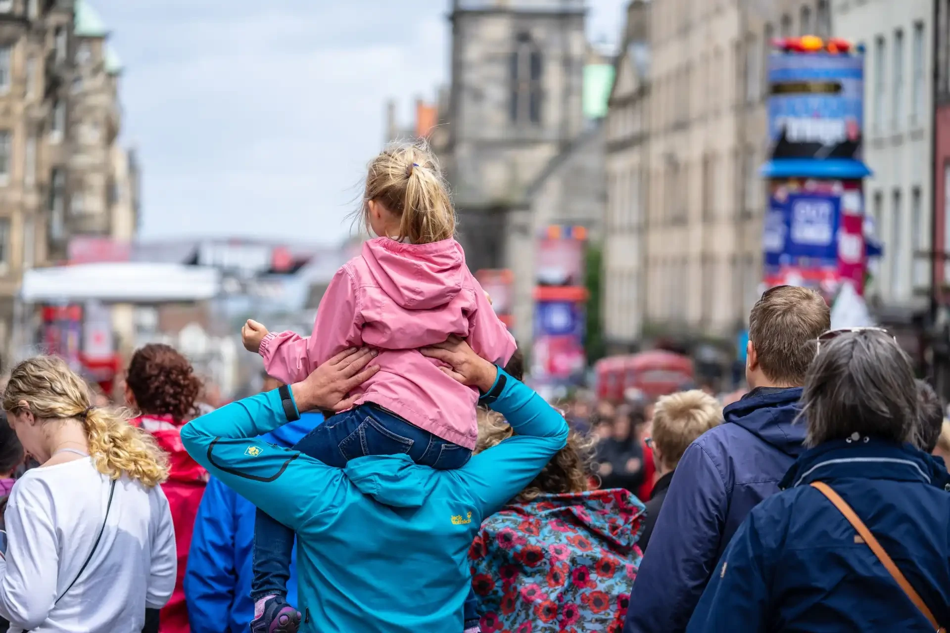 The vibrant atmosphere of the Edinburgh Festival Fringe is captured in a lively crowd scene.