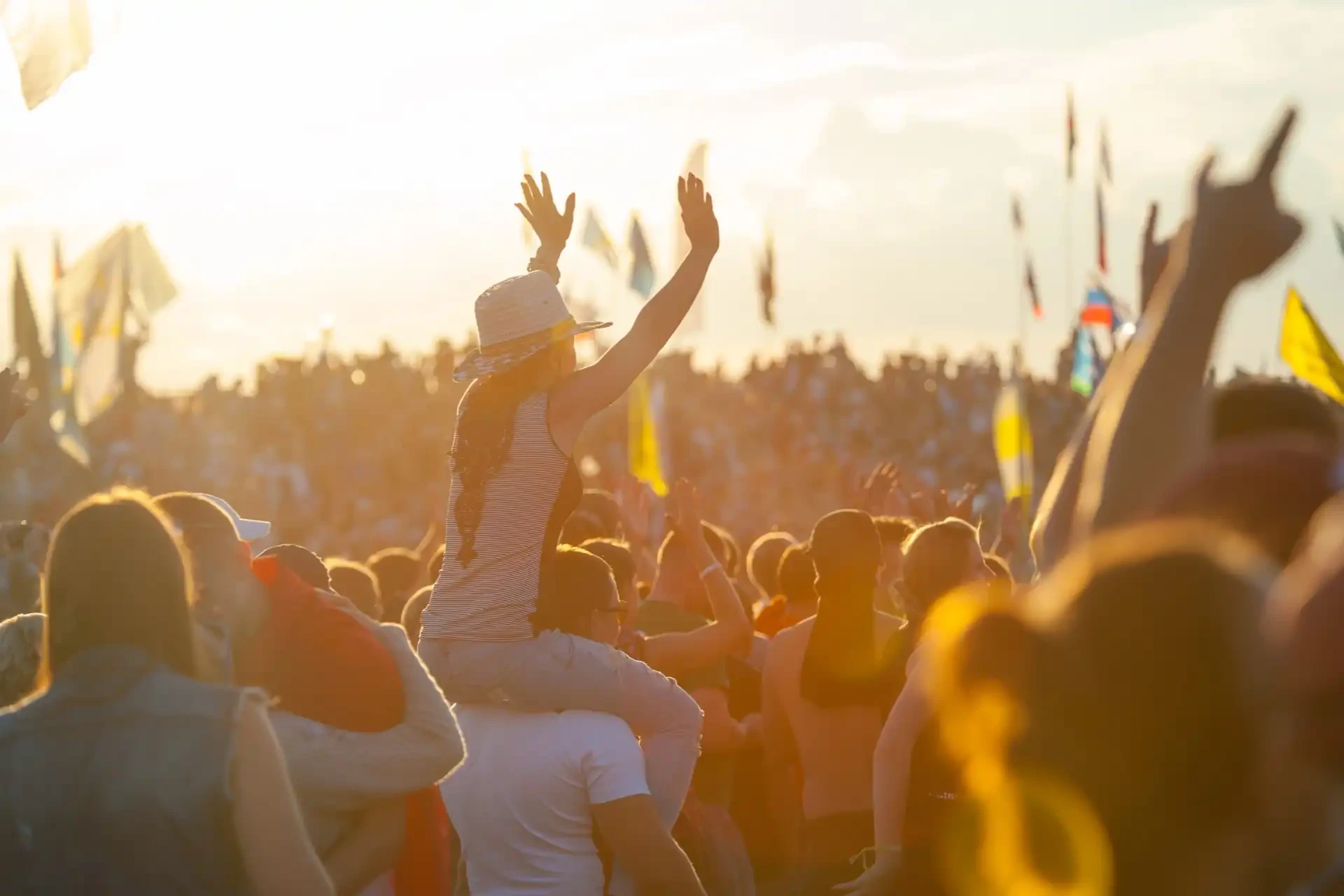 A lively summer scene at Glastonbury Festival shows a diverse and energetic crowd, enjoying live music.