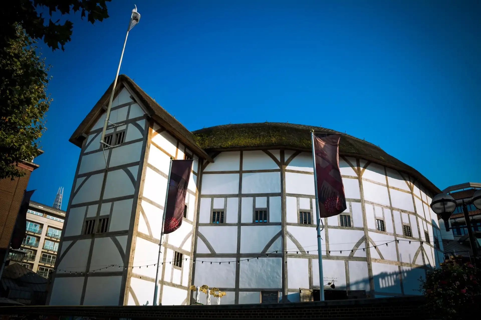 Shakespeare’s Globe, a reconstructed Elizabethan theatre with a thatched roof, wooden structure, and open-air stage.