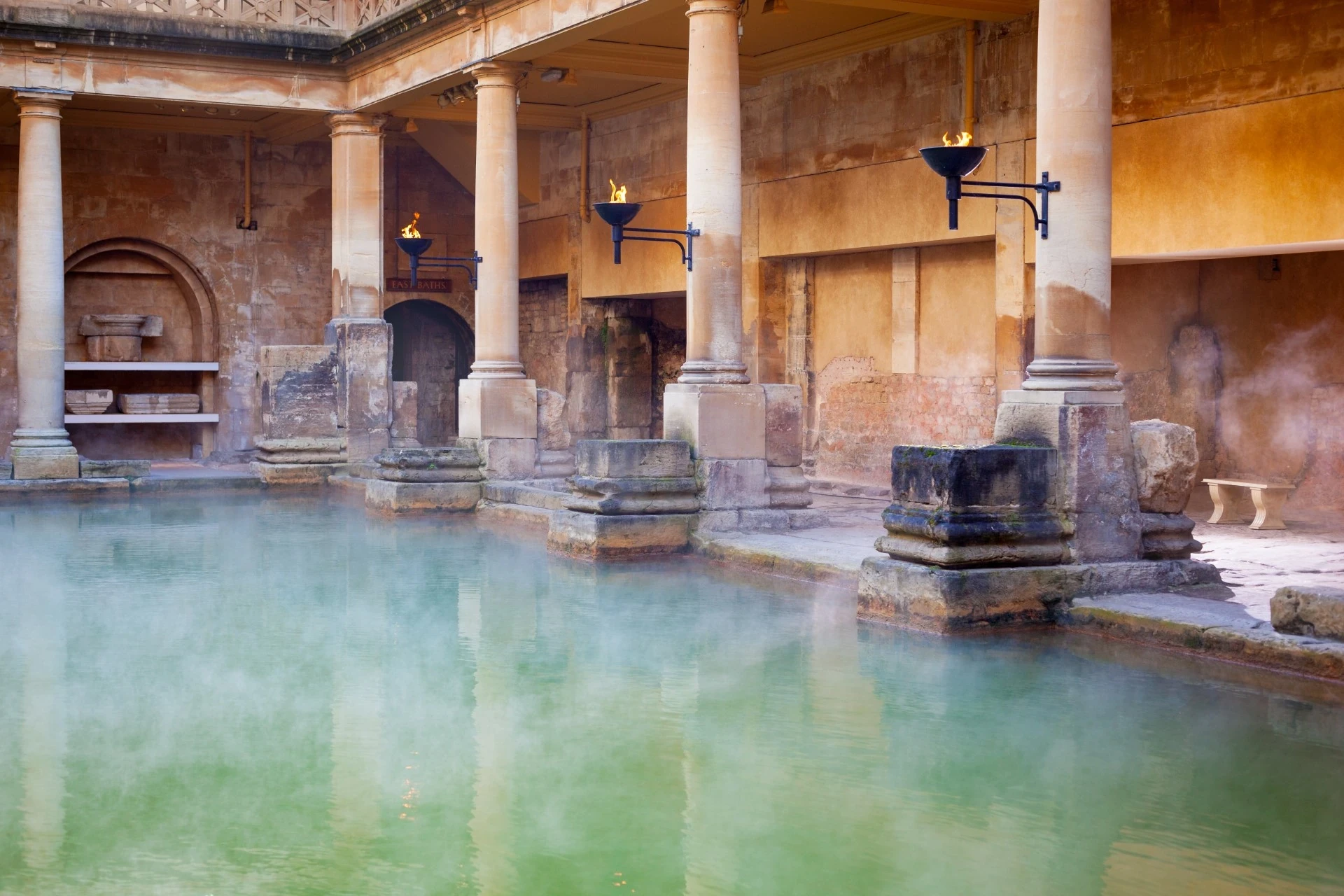 The Roman Baths, a well-preserved ancient bathing and social complex, featuring intricate columns and architecture.