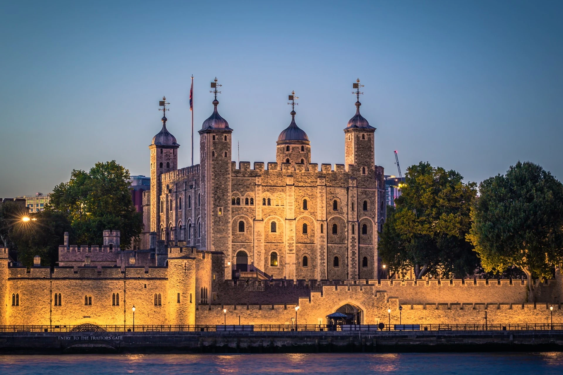 A historic castle with turrets and walls, the Tower of London stands tall against the night sky.