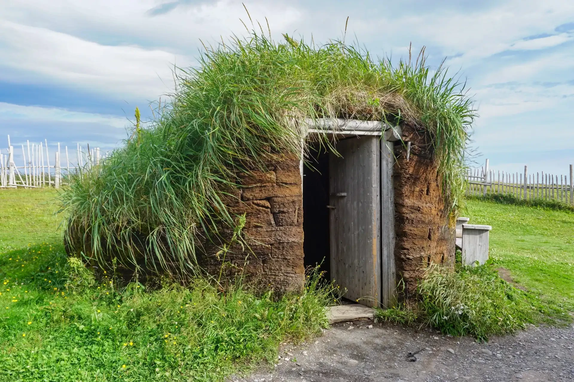 A historic green-roofed home built by the Norse people at L’Anse aux Meadows in Newfoundland and Labrador, a UNESCO World Heritage Site showcasing Viking archaeological remains.