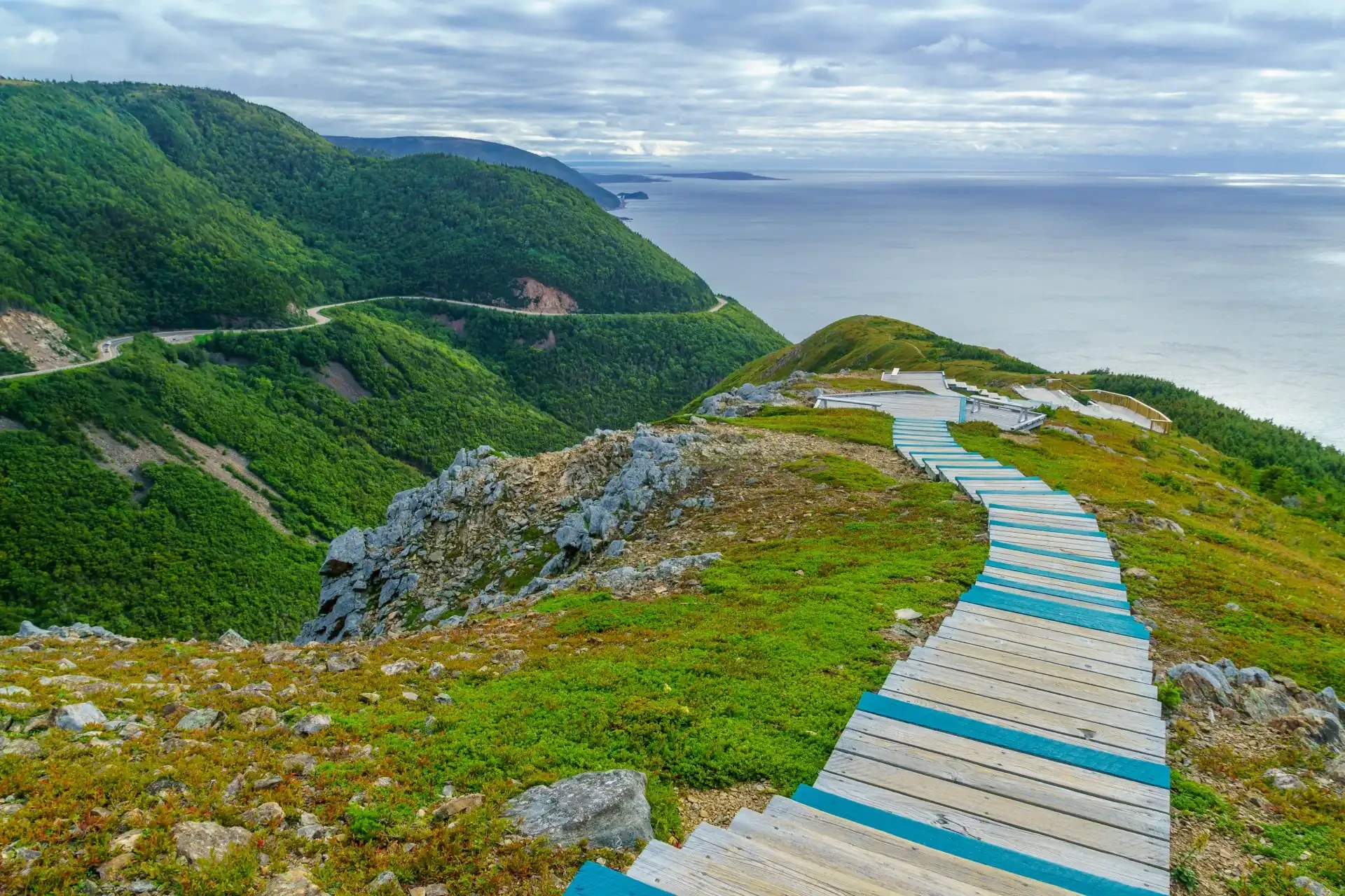 The Cape Breton Highlands in Nova Scotia, Canada, showcasing a picturesque landscape with rugged cliffs, scenic coastal views, and a winding pathway.