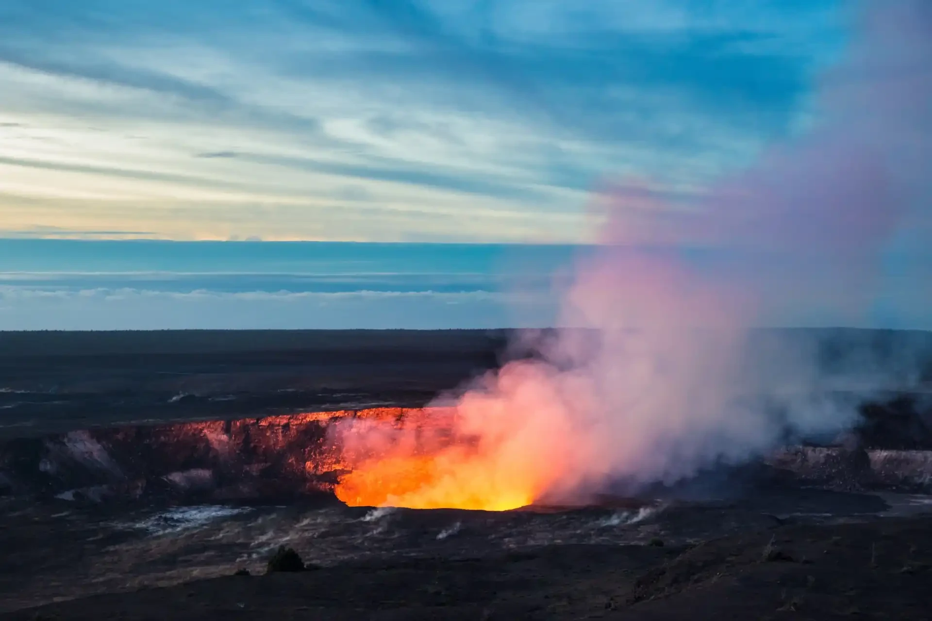 A volcanic landscape with lava flows and steaming vents at Hawaiʻi Volcanoes National Park.