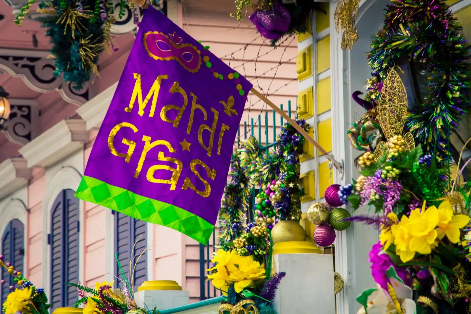 Mardi Gras celebration: A lively, colourful flag outside a house adorned with vibrant flowers and festive decorations.