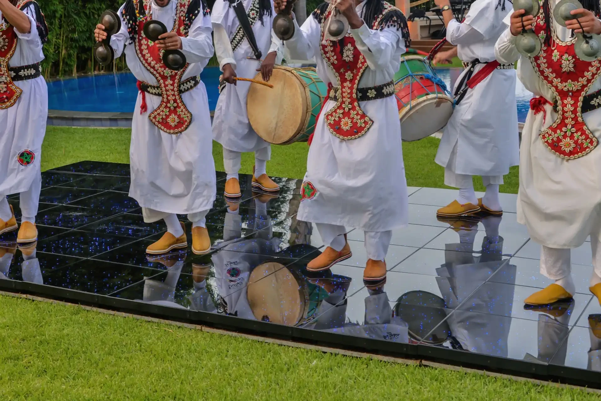 Musicians dressed in national costumes playing traditional instruments at a lively Gnawa festival.