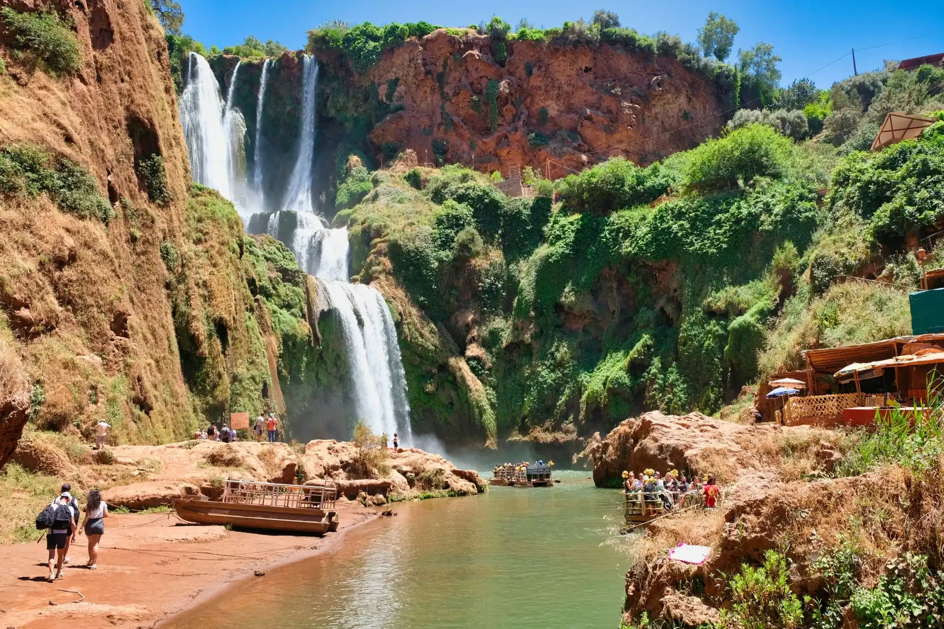 Ouzoud Falls in Morocco surrounded by greenery with people enjoying the view.