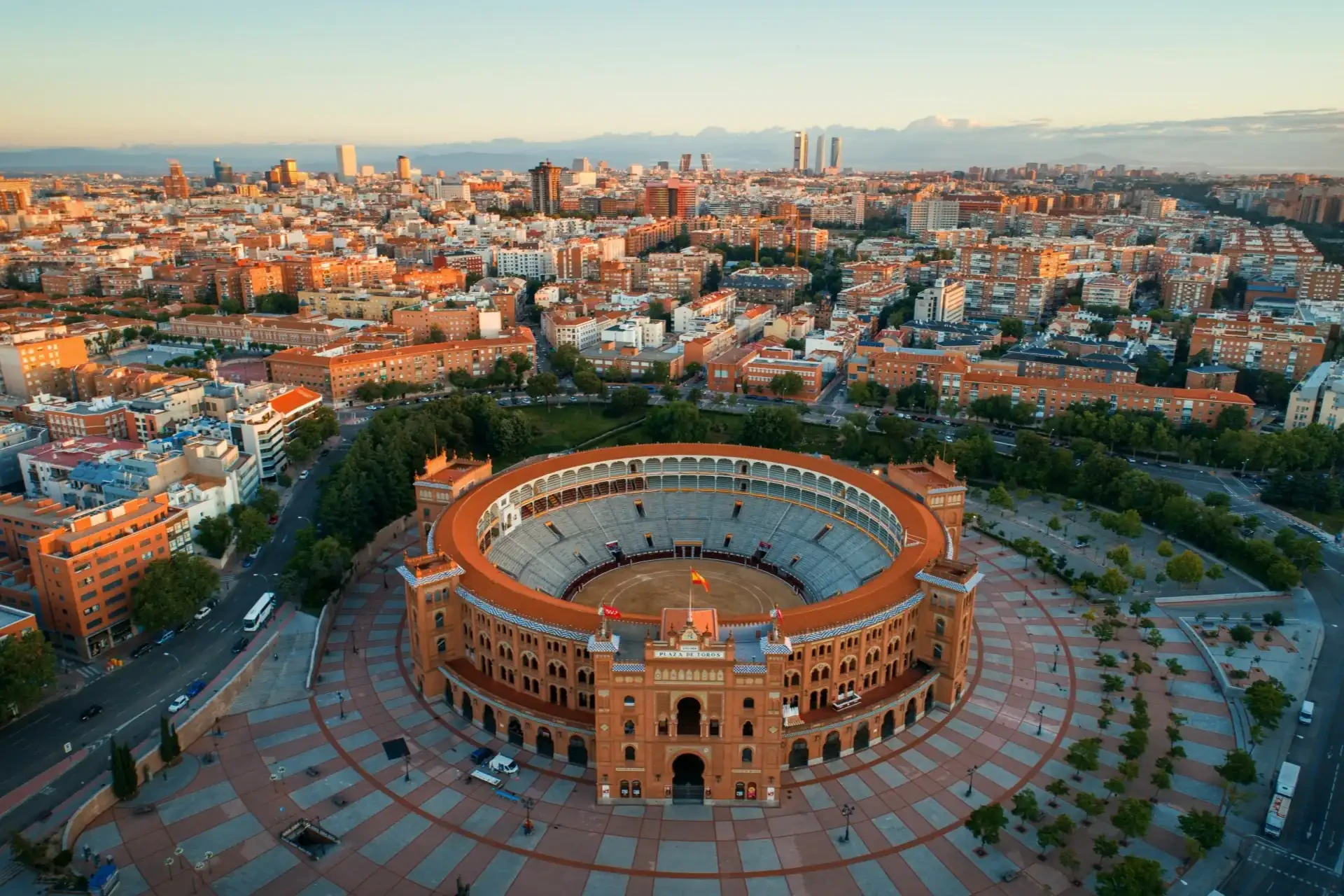 An aerial view of Madrid's Las Ventas Bullring, where bullfights take place. Surrounding buildings provide a backdrop to the iconic arena.