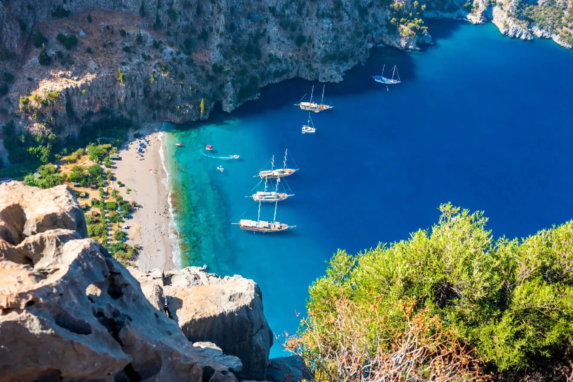 An aerial view of Butterfly Valley in Fethiye, Turkey, surrounded by lush greenery and cliffs, known for its diverse butterfly species.