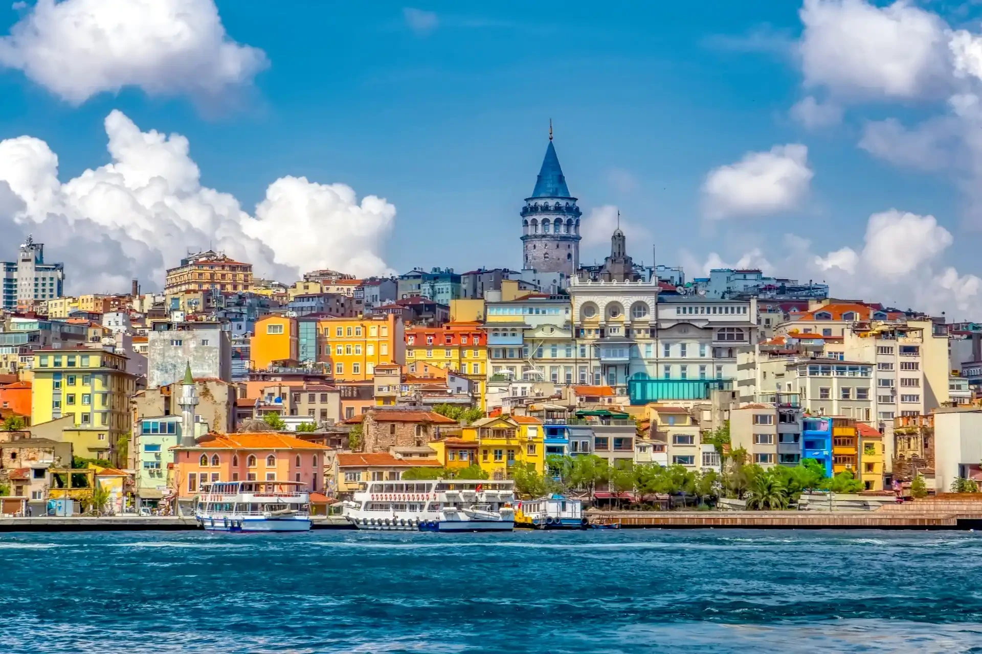 Galata Tower in Istanbul during spring, surrounded by blue skies and colourful buildings.