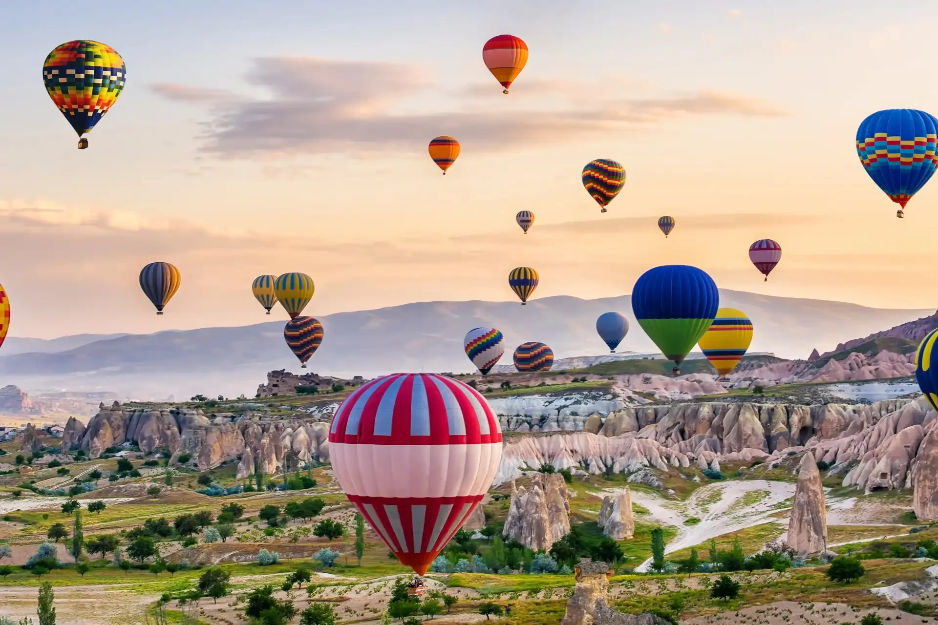 Colourful hot air balloons drifting over the surreal landscapes of Cappadocia.